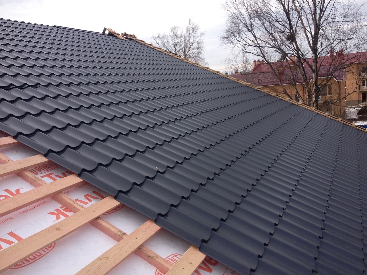 кровельное покрытие. сложная кровля из металлочерепицы. фальцевая кровля. на крыше. строительные материалы для крыши.
