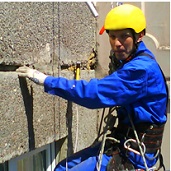 Заполнение трещин в бетоне на стене многоэтажного здания