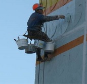 Промышленные альпинисты выполняют работы по капитальному ремонту фасада дома