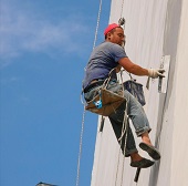 Промышленные альпинисты оштукатуривают верхние этажи здания