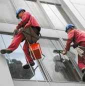 Промышленные альпинисты моют окна в многоэтажном жилом доме